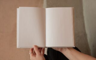 Some hands holding a blank book